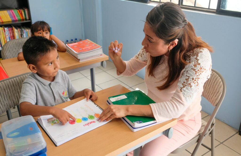 Teacher working with a young student in a classroom